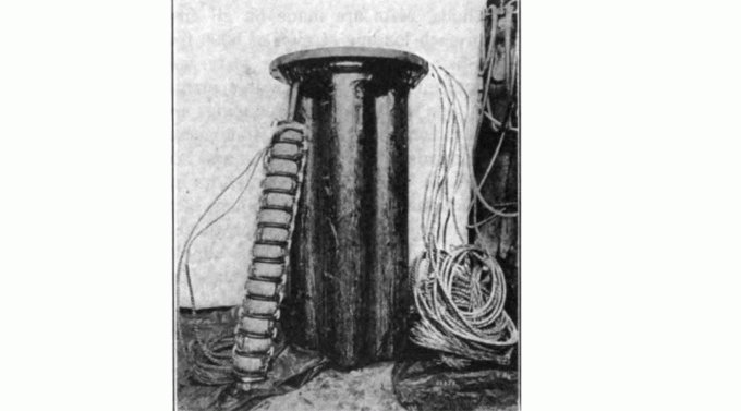 Контейнер за поставяне на намотки Pupin. 14 шпули бяха поставени на вретено (облегнато на тялото), седем вретена бяха вкарани в напълнено с масло тяло, поставено на един от стълбовете на линията на всеки 6000 фута (1800 м)